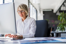 Woman using a computer to upload documents.